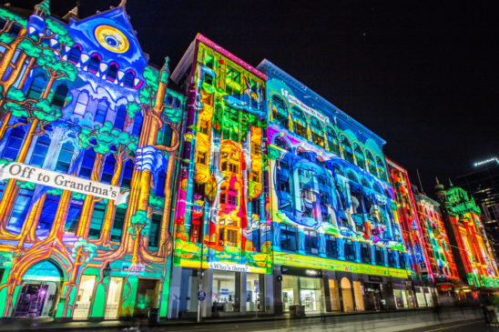 Projection mapping example of colors projected onto buildings.