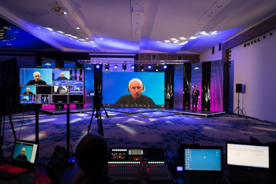 Virtual event host is on screen at a business conference after prepping to get camera-ready.